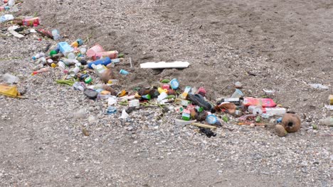 Environmental-disaster-with-piles-of-plastic-waste-and-rubbish-washed-ashore-onto-beach-at-high-tide-in-tropical-island-destination-in-East-Timor,-Southeast-Asia