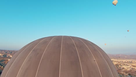 Hot-Air-Balloons-Flying-Against-Blue-Sky-In-Cappadocia,-Turkey---Drone-FPV