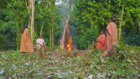 Stammesfamilie-Um-Ein-Feuer-In-Einem-üppigen-Peruanischen-Dschungel,-Mit-Einem-Kind-In-Traditioneller-Kleidung