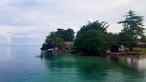 Malerische-Aussicht-Auf-Menschen,-Die-Auf-Einer-Tropischen-Insel-In-Der-Abgelegenen-Westlichen-Provinz-Ein-Traditionelles-Kanu-Im-Wunderschönen-Türkisfarbenen-Meerwasser-Paddeln