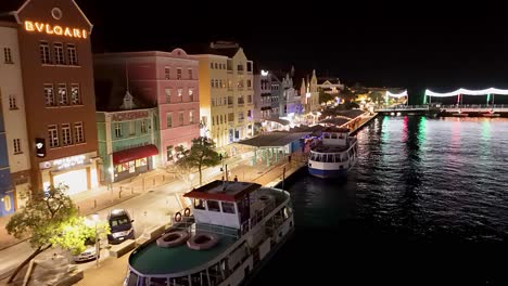 Plataforma-Rodante-Aérea-Sobre-Edificios-De-Ferry-Y-Handelskade-Por-La-Noche-En-Willemstad-Curacao