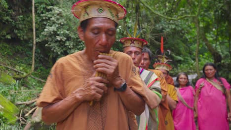 Indigenous-men-playing-flute-with-group-of-women-in-traditional-dress,-Oxapampa,-Peru,-daytime,-cultural-ceremony