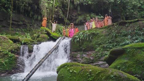 Grupo-De-Nativos-Con-Atuendo-Tradicional-Celebrando-En-Un-Exuberante-Bosque-Verde-Como-Telón-De-Fondo-Con-Una-Cascada-En-Oxapampa,-Perú