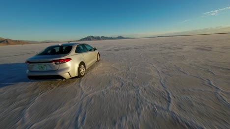 FPV-Drohne,-Die-Einem-Auto-Folgt,-Das-Entlang-Der-Bonneville-Salinen-In-Utah-Fährt