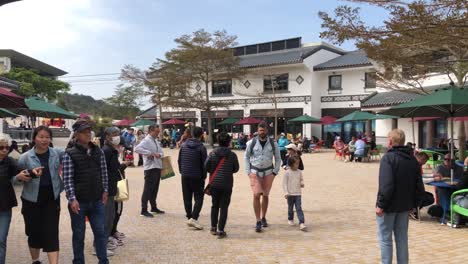 La-Gente-Disfruta-De-La-Zona-Del-Restaurante-En-Un-Día-Soleado-En-La-Aldea-De-Ngong-Ping,-Isla-De-Lantau,-Hong-Kong