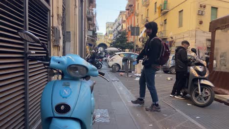 Niño-Morisco-Jugando-En-Las-Calles-De-Nápoles,-Cerca-De-Una-Motocicleta-Vespa