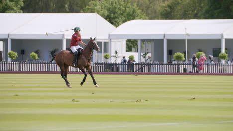 Los-Jugadores-De-Polo-Balancean-Su-Mazo-Y-Golpean-La-Pelota-Mientras-Montan-Un-Caballo-Castaño.