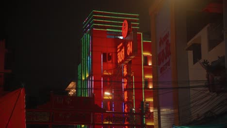 Glowing-building-with-neon-signs-and-decorations-light-up-at-night-in-Chinatown,-Bangkok