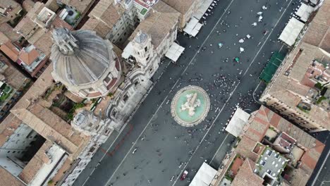 Toma-Aérea-De-Una-Explanada-Pública-Llena-De-Gente-Y-Edificios-En-La-Ciudad-De-Roma.