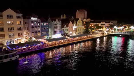 Retirada-Aérea-Desde-El-Paseo-Marítimo-De-Willemstad-Curacao-Con-Ferry-Por-La-Noche