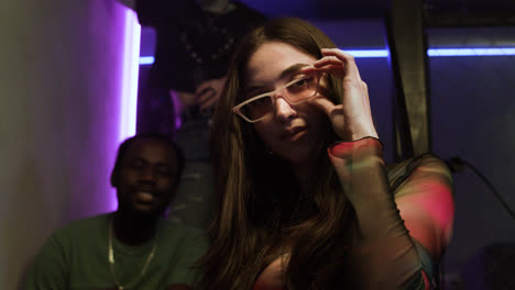 Young-woman-posing-indoors-with-sunglasses