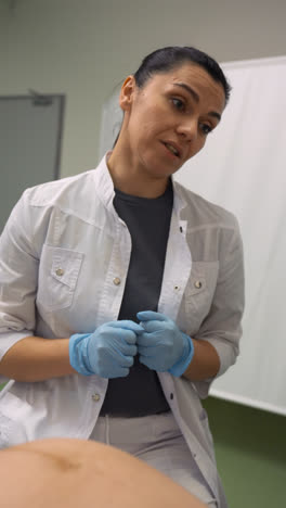 Female-doctor-with-blue-gloves-talking-with-patient