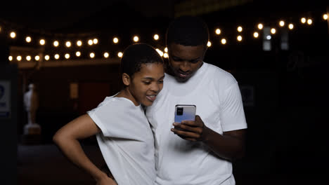 Couple-watching-video-on-device-at-the-street