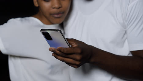 Couple-watching-video-on-device-at-the-street