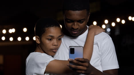 Couple-watching-video-on-device-at-the-street