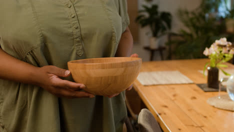 Woman-putting-bowl-on-the-table