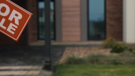 Man-putting-for-sale-banner-on-garden