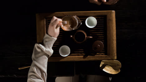 Woman-pouring-tea-in-a-glass-jar