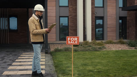 Man-checking-blueprints-on-clipboard