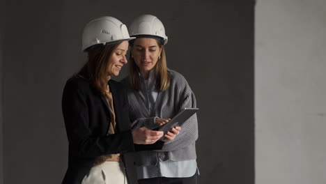 Frauen-Mit-Bauhelmen-Unterhalten-Sich-In-Einem-Leeren-Haus