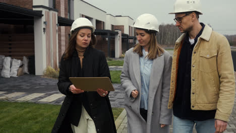 People-with-hardhats-talking-and-walking-outdoors