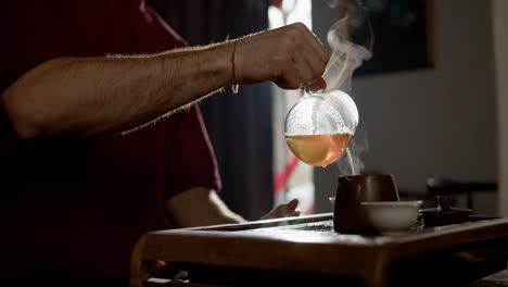 Hombre-Sirviendo-Té-En-Taza