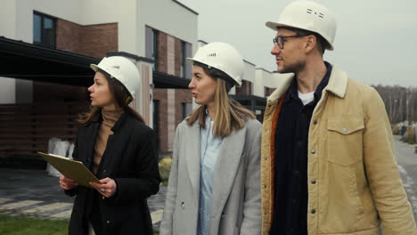 People-with-hardhats-talking-and-walking-outdoors