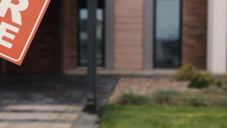 Woman-putting-for-sale-banner-on-garden