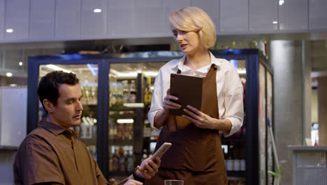 Waitress-attending-table-and-taking-notes