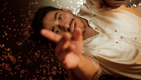 Happy-man-laying-on-the-floor-with-confetti