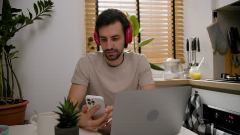 Guy-using-smartphone-and-laptop