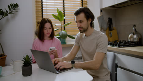 Couple-using-gadgets-at-home