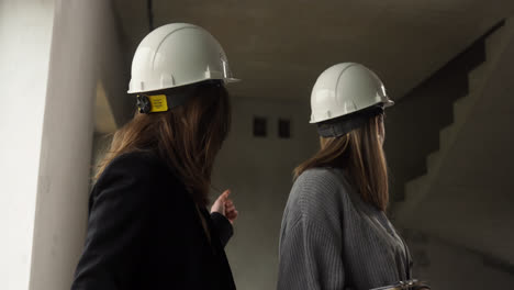 Frauen-Mit-Bauhelmen-In-Einem-Leeren-Haus