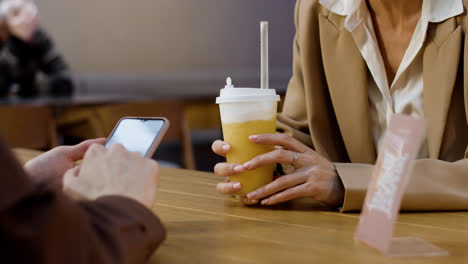 Woman-drinking-beverage-and-talking-with-friend