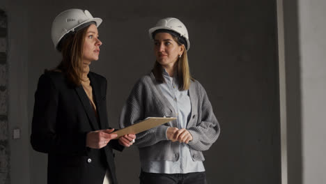 Women-with-hardhats-talking-in-house-under-construction