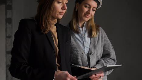 Mujeres-Con-Cascos-De-Seguridad-Hablando-En-Una-Casa-Vacía