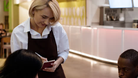 Waitress-attending-table-and-taking-notes