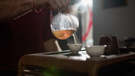 Mann-Serviert-Tee-Auf-Tasse