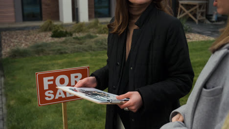 Real-estate-agent-holding-clipboard-with-drawings