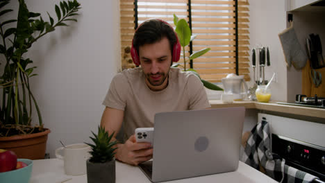 Guy-using-smartphone-and-laptop