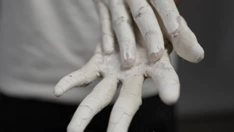 Person-removing-layer-of-paint-from-hands