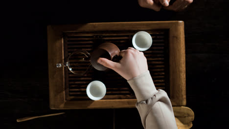 Woman-pouring-tea-in-a-glass-jar