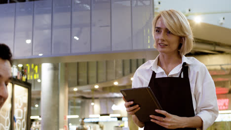 Waitress-attending-table-with-tablet