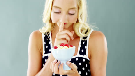 Beautiful-woman-looking-at-fruit-salad-in-bowl