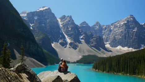 Couple-sitting-on-a-rock-near-riverside-4k