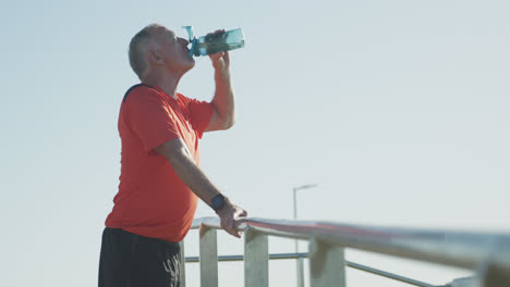 Hombre-Mayor-Bebiendo-Agua-En-El-Paseo-Marítimo