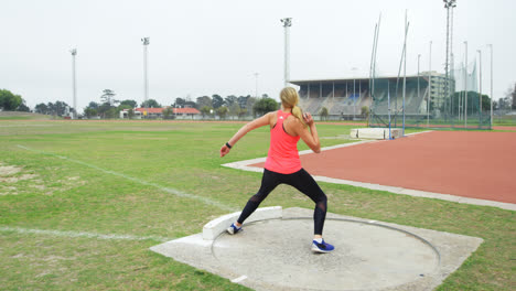 Rückansicht-Einer-Kaukasischen-Sportlerin,-Die-Kugelstoßen-Auf-Einer-Sportstätte-übt,-4k