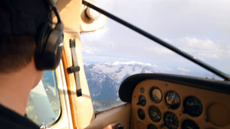 Pilot-flying-aircraft-over-snowcovered-mountain-4k