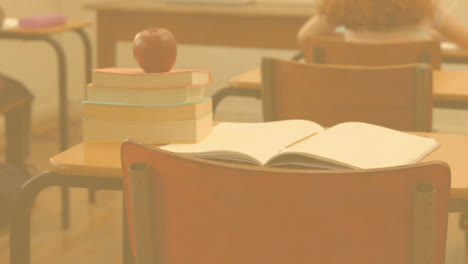 Pow-text-on-speech-bubble-against-stack-of-books-and-apple-on-school-desk