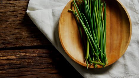 Fresh-garlic-chives-in-wooden-plate-4k